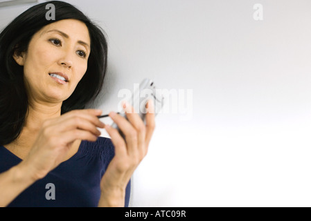 Frau mit Palmtop, niedrigen Winkel Ansicht Stockfoto
