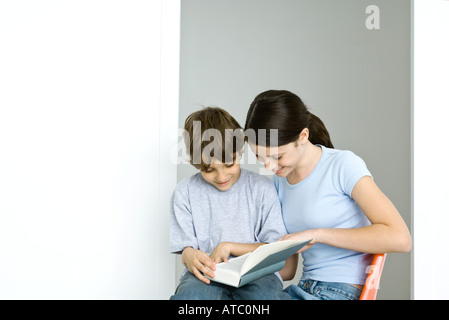 Bruder und Schwester zusammensitzen, Lesebuch, beide Lächeln Stockfoto