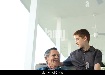 Großvater und Enkel sitzen zusammen auf der Veranda, niedrigen Winkel Ansicht Stockfoto