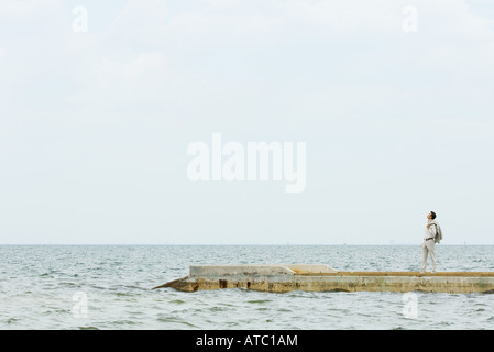 Mann steht am Pier, Blick nach oben, in der Ferne Stockfoto