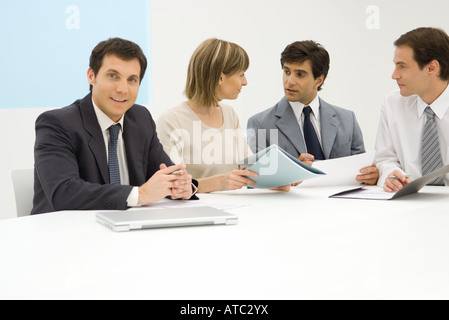 Team von Geschäftspartnern am Tisch sitzen, Dokument, ein Lächeln in die Kamera zu diskutieren Stockfoto