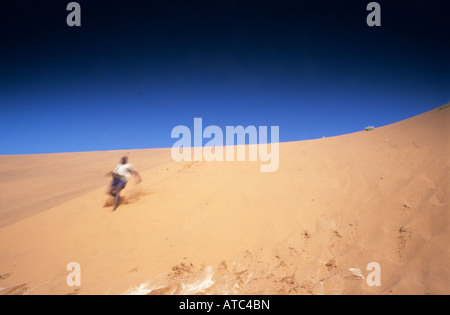 Ein Mann läuft auf einer Sanddüne Stockfoto