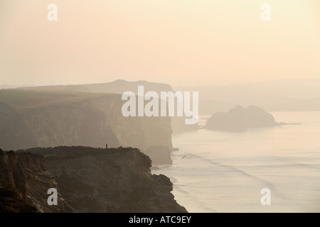 eine einzelne Figur steht auf der Landzunge, Blick auf das Meer und die Klippen Stockfoto