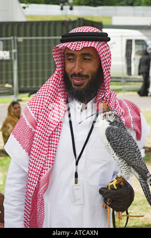 Ein Saudi Mann mit einem vermummten Falken an einer arabischen Messe. Heaton Park, Manchester, Greater Manchester, Vereinigtes Königreich. Stockfoto