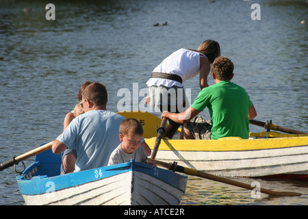 An einem sonnigen Sommernachmittag genießen, eine junge Familie und ein junges Paar Rudern auf eine bloße Suffolk Stockfoto