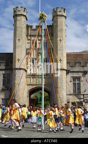 Wells Somerset UK Kinder tanzen am Maipol auf dem Market Place mit dem Bishops Eye Tower hinter dem Maitag Stockfoto