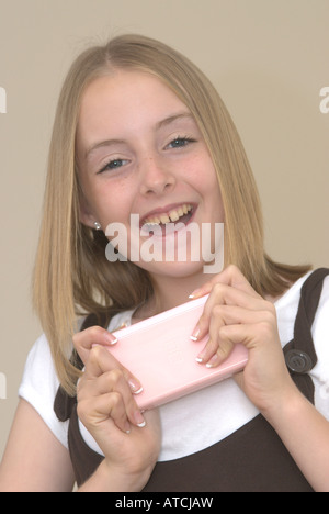 Junges Mädchen hält eine Nintendo DS lite Konsole UK Stockfoto