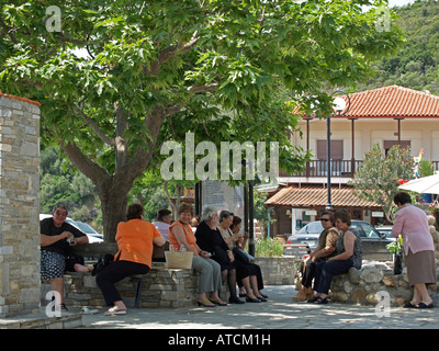Frauen jung und alt im Chat am Dorfplatz im Schatten unter einer großen Platane auf der Halbinsel Halkidiki Chalkidiki Griechenland Stockfoto