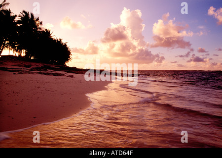 Die Sonne beginnt zu setzen in einem wolkigen Himmel über einem Strand auf den Bahamas Stockfoto