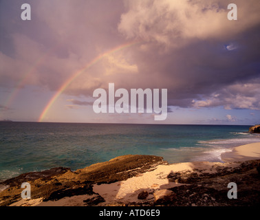 Ein Regenbogen durchbricht Gewitterwolken über Cupecoy Bay St Maarten Stockfoto