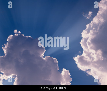 Lichtstrahlen Platzen von hinten flauschigen weißen Cumulus-Wolken Stockfoto