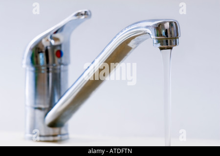 Wasser aus einem Stahl Hahn gießen. Stockfoto