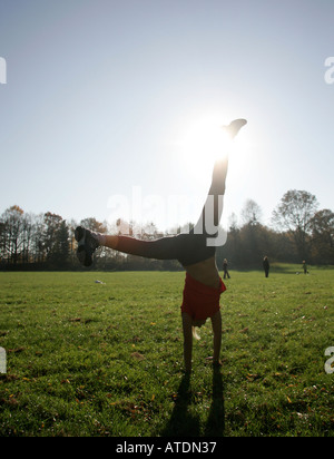 Silhouette einer jungen Frau im Park cartwheeling