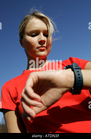 Porträt einer jungen blonden Frau auf der Suche auf ihre Pulsemeter Uhr Stockfoto