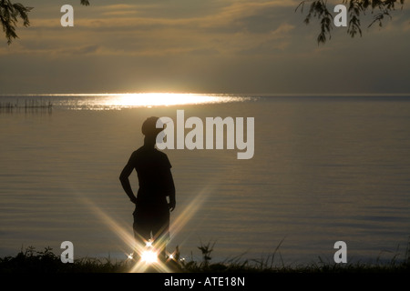Silhouette der jungen Frau See stehen Stockfoto
