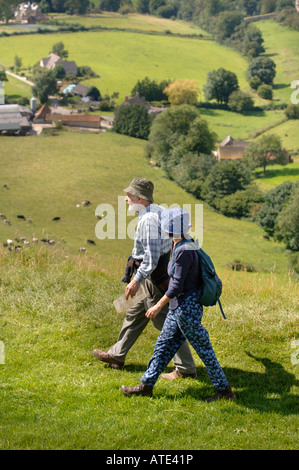 EIN PAAR WANDERER ÜBERQUEREN ULEY BEGRABEN AUF DEM COTSWOLD WEG IN DER NÄHE VON DURSLEY Stockfoto