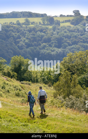 EIN PAAR WANDERER ÜBERQUEREN ULEY BEGRABEN AUF DEM COTSWOLD WEG IN DER NÄHE VON DURSLEY Stockfoto