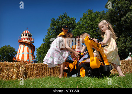 ELTERN HELFEN IHREN KINDERN ZU, AUF SPIELZEUG BAGGER SPIELEN A INNOCENT VILLAGE FETE IM REGENTS PARK LONDON 2007 Stockfoto