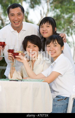 Porträt von Eltern und ihren beiden Töchtern Toasten mit Wein Stockfoto