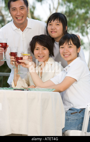 Porträt von Eltern und ihren beiden Töchtern Toasten mit Wein Stockfoto