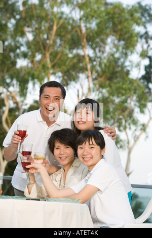 Porträt von Eltern und ihren beiden Töchtern Toasten mit Wein Stockfoto