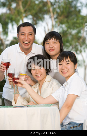 Porträt von Eltern und ihren beiden Töchtern Toasten mit Wein Stockfoto