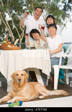 Porträt von Eltern und ihren beiden Töchtern Toasten mit Wein Stockfoto