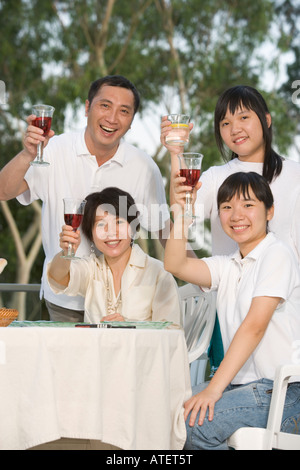 Porträt von Eltern und ihren beiden Töchtern Toasten mit Wein Stockfoto