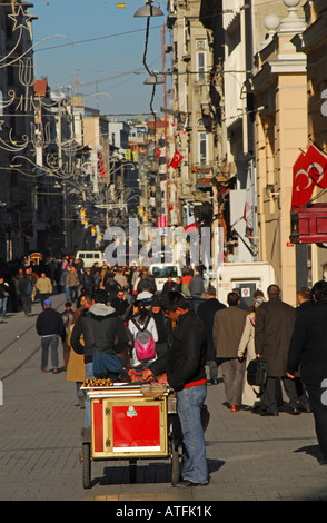 ISTANBUL, TÜRKEI. Samstag-Shopper auf Istiklal Caddesi im Stadtteil Beyoglu, mit einer Kastanie Verkäufer im Vordergrund. 2007. Stockfoto