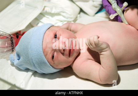 Ein neugeborenes Baby junge wirft einen Blick in Minuten nach der Geburt, mit Nabelschnur noch befestigt. Stockfoto