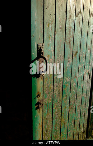 Eine alte verwitterte grün aus Holz, Tür offen gelassen. Stockfoto
