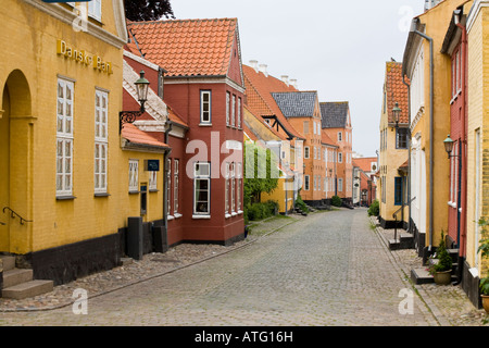 Hinunter zum Hafen. Einer schmalen gepflasterten Straße gesäumt von bunten Häusern führt gerade nach unten in Richtung Hafen Stockfoto