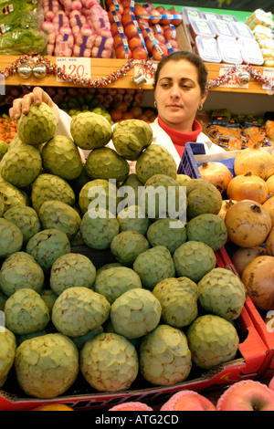 Spanierin Obst-Verkäufer mit Stapel der Cherimoya Custard Apple Gibraltar indoor Markt Großbritannien Europa Stockfoto