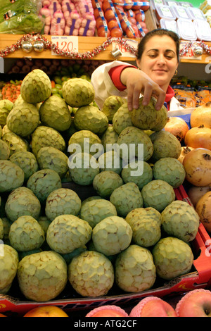 Spanierin Obst-Verkäufer mit Stapel der Cherimoya Custard Apple Gibraltar indoor Markt Großbritannien Europa Stockfoto