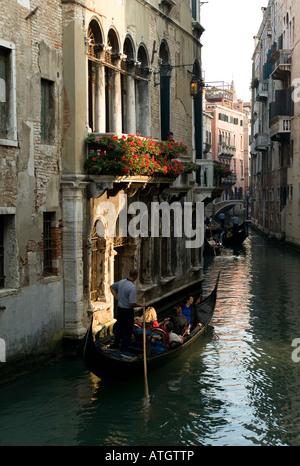 Gondoliere nimmt Touristen auf Gondel unten Seitenkanal in Venedig Italien Stockfoto