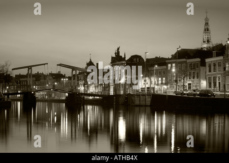 Schwarzweißansicht des Flusses Spaarne mit Gravestenenbrug Zugbrücke in Haarlem, Holland, Niederlande in der Abenddämmerung. Stockfoto