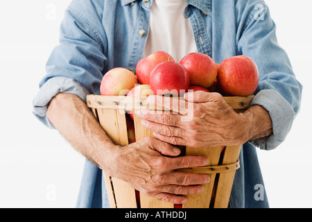 Man Betrieb Korb Äpfel Stockfoto