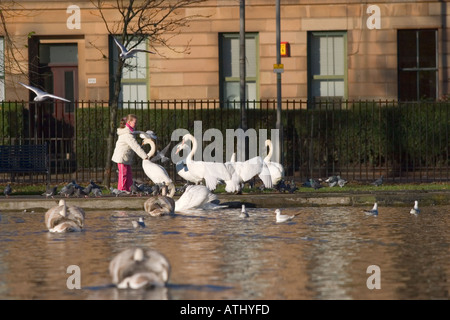 Mädchen, die Fütterung von Schwänen in Queens Park Stockfoto