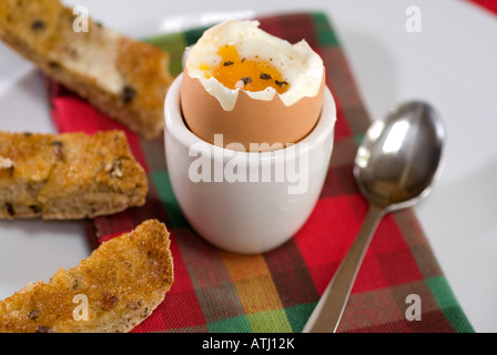 Ein weich gekochtes Ei mit Getreidespeicher Brot Soldaten auf einer bunten Tisch-Serviette Stockfoto