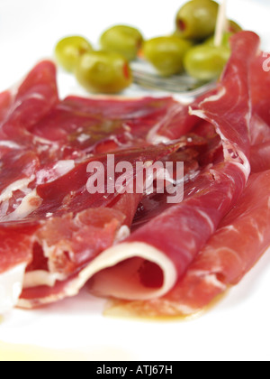 Eine spanische Tapa der dünn geschnittenen Jamon Iberico de Bellota, mit Paprika gefüllte Oliven hinter. 2008. Stockfoto