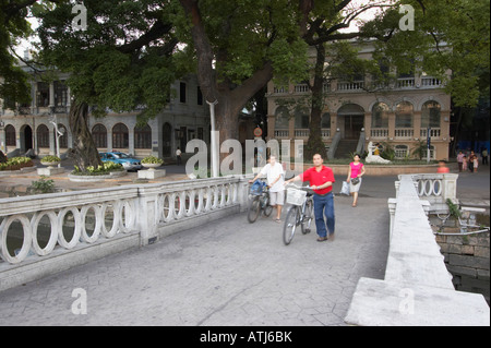 Menschen drängen Bikes über Brücke auf Shamian Insel, Guangzhou Stockfoto