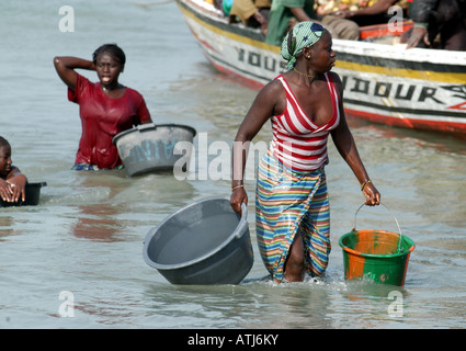 FRAU, DIE DEN FANG ENTLADEN IN TANJI. EIN FISCHERDORF IN DER GAMBIA WESTAFRIKA. Stockfoto