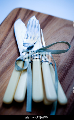 Vintage Messer und Gabeln erschossen auf einem hölzernen Brot-Brett Stockfoto