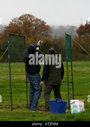 zwei Männer Tontaubenschießen mit einer Schrotflinte auf dem Lande in Wiltshire England uk Stockfoto