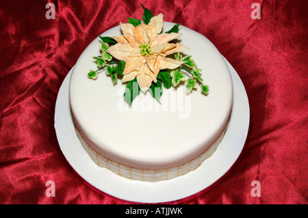 Eine schön gestaltete Hand verziert Geeiste Obstkuchen auf rotem satin in einem Studio mit Flash-Design von Pam Hannon Stockfoto