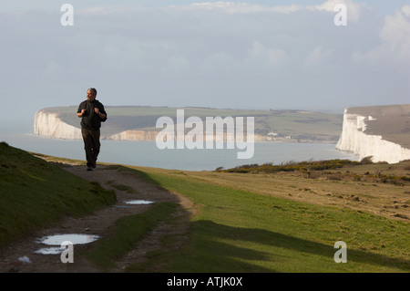 Ein Wanderer nach der South Downs Way in der Nähe von Birling Gap und sieben Schwestern in Sussex UK Stockfoto