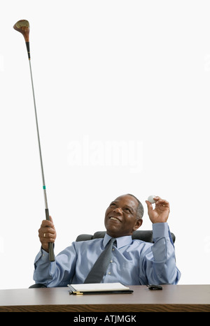 Geschäftsmann am Schreibtisch sitzt und auf der Suche in einem Golfclub Stockfoto