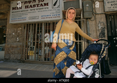 Eine Frau mit ihrem Baby vor ein Closed shop Stockfoto