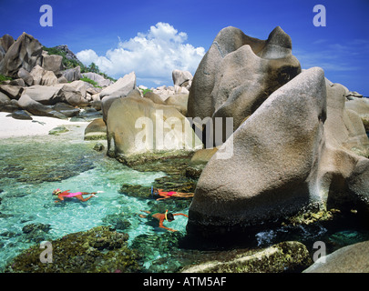 Touristen, die Schnorcheln im Gezeiten-Pools auf der Insel La Digue auf den Seychellen Stockfoto