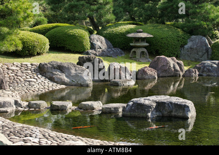 Eine traditionelle Steinlaterne mit Blick auf eine kleine Karpfen-Teich in einem traditionellen japanischen Garten Schloss Nijo Kyoto Japan Asien Stockfoto